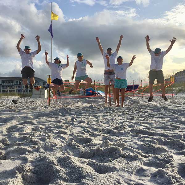 South Walton Turtle Watch volunteers jumping for joy on the beaches of South Walton County, Florida in after finding a sea turtle nest.