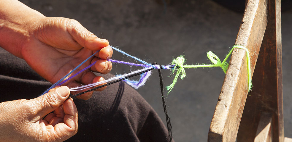Woman's hands weaving friendship bracelet at all women coop in Chiapas Mexico