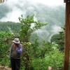 Bolivian coffee producer stands surrounded my lush green forests and mist high in the Yungas Mountain landscape.