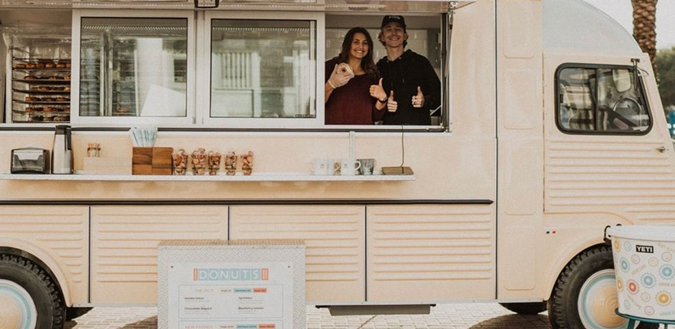 Donut Truck Blog Feature Photo. Amavida Donuts employees serving up donuts and smiles from the new vintage inspired donut truck in Seaside, FL.